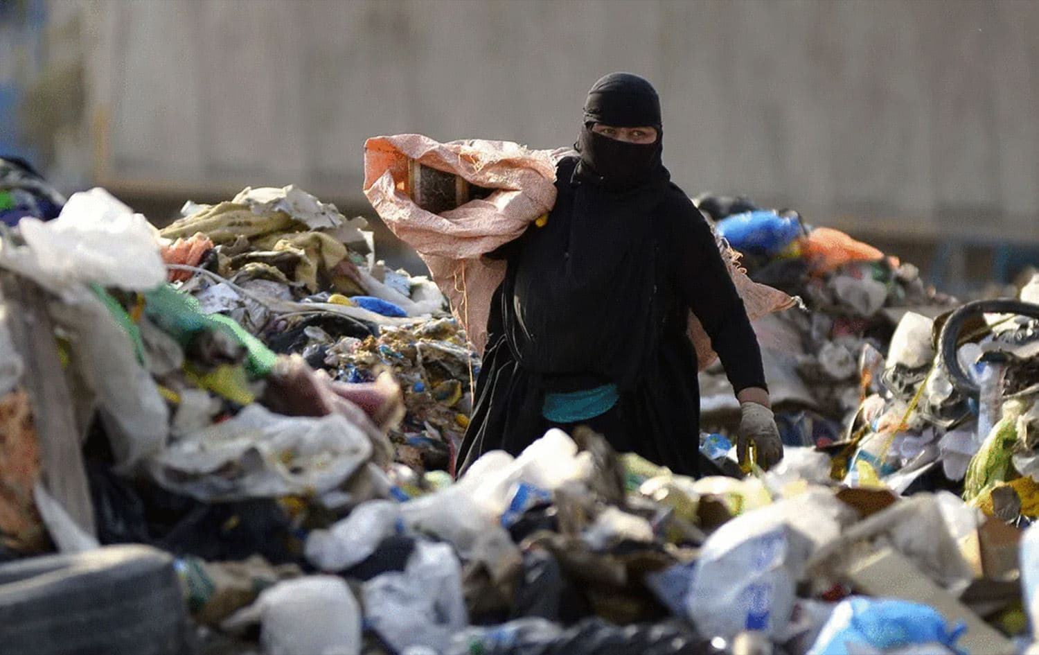 امرأة تنقب في النفايات - ارشيفية