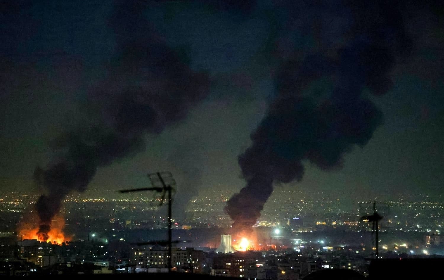 تصاعد دخان كثيف من حريق بجوار برج آزادي عقب غارات جوية قرب مطار مهرآباد الدولي في طهران -AFP