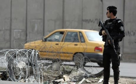 عنصر امن عراقي يقف عند نقطة تفتيش غربي بغداد - AFP