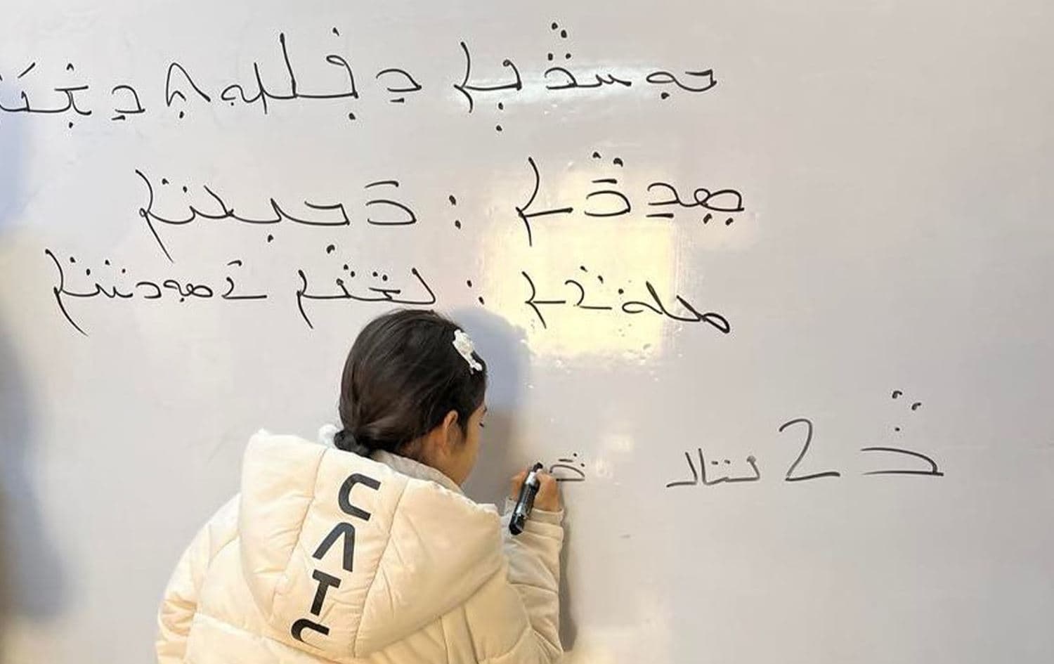 طفلة تدرس باللغة السريانية