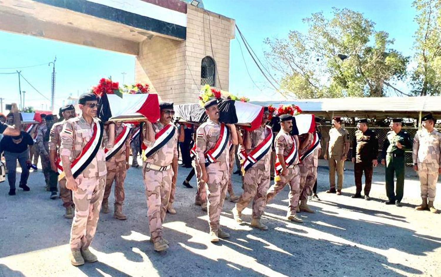 ضبّاط عراقيون يحملون نعوش رفات ضحايا قضوا في الحرب العراقية الإيرانية خلال الثمانينيات