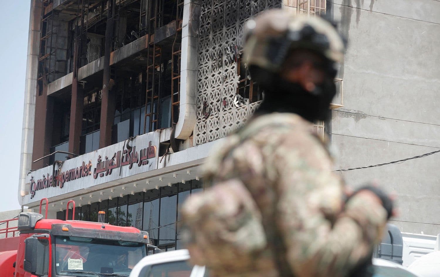 أحد أفراد قوات الأمن أمام الهايبر ماركت الذي اندلع فيه الحريق / الكوت - AFP