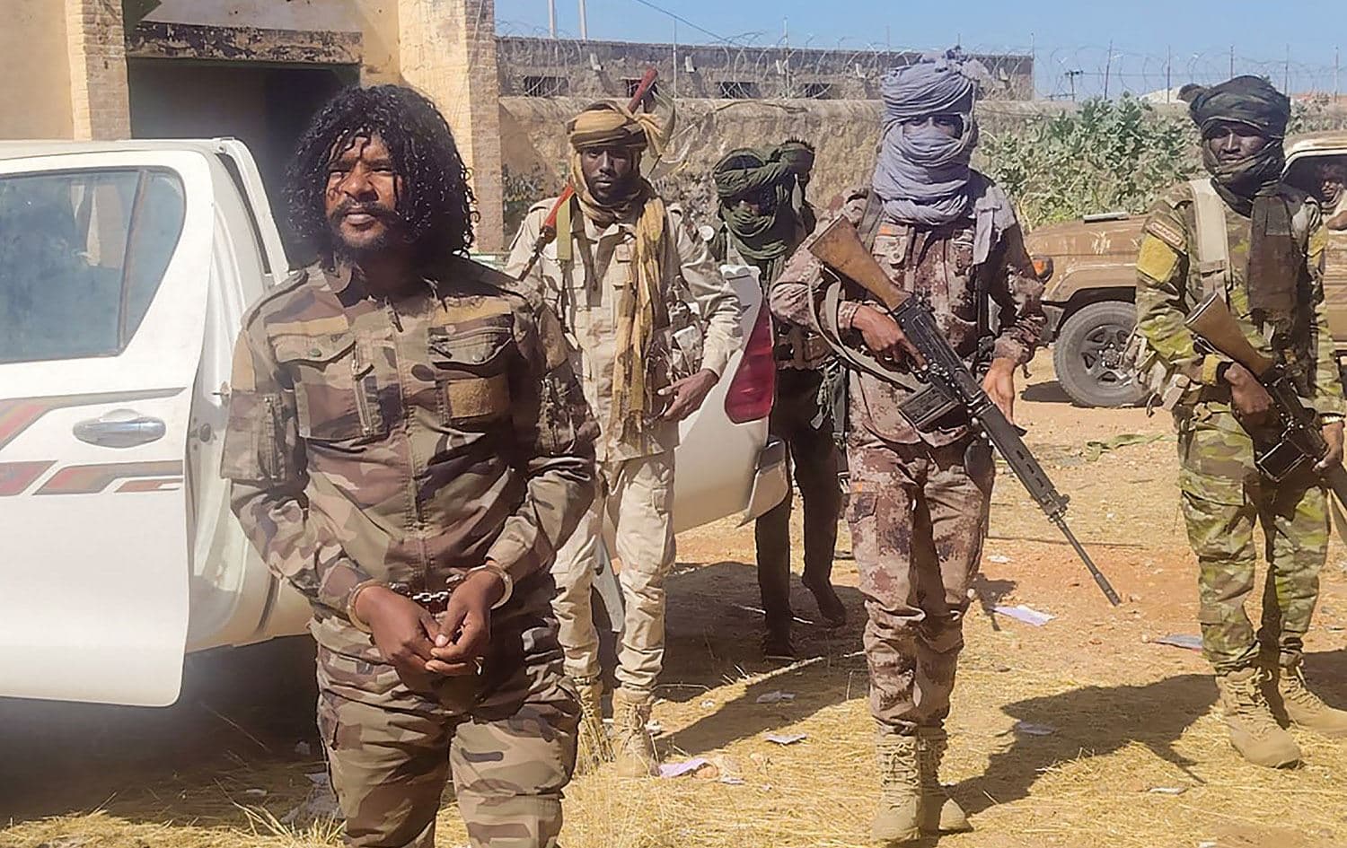 صورة وزعتها قوات الدعم السريع السودانية تظهر عدداً من عناصرها وهم يحتجزون مقاتلاً يُعرف باسم "أبو لولو" متهم بارتكاب "انتهاكات"-AFP