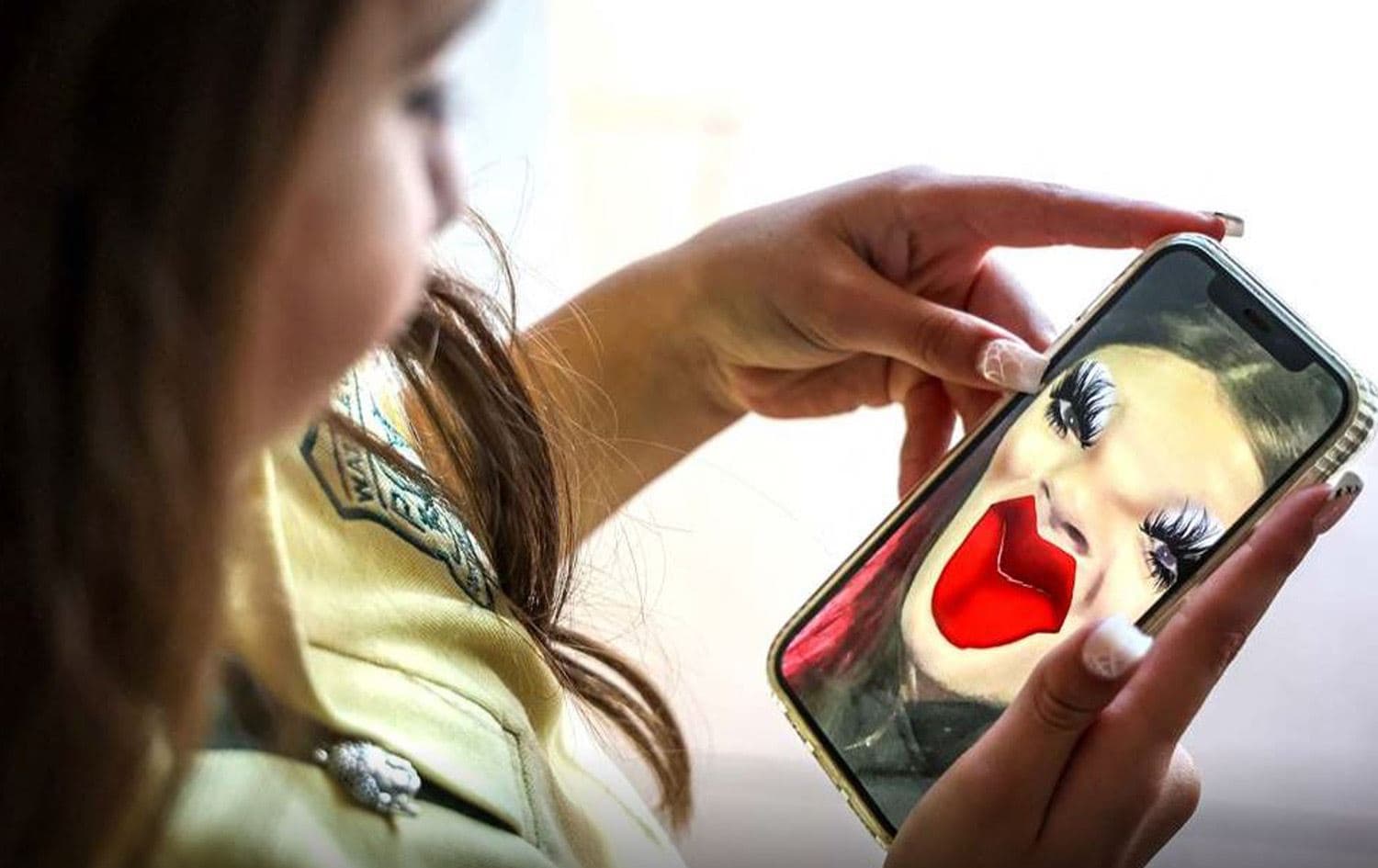 بيانكا نافارو البالغة من العمر 10 سنوات وهي تتصور مع لقطة شاشة لنفسها من تطبيق "سناب تشات"-AFP